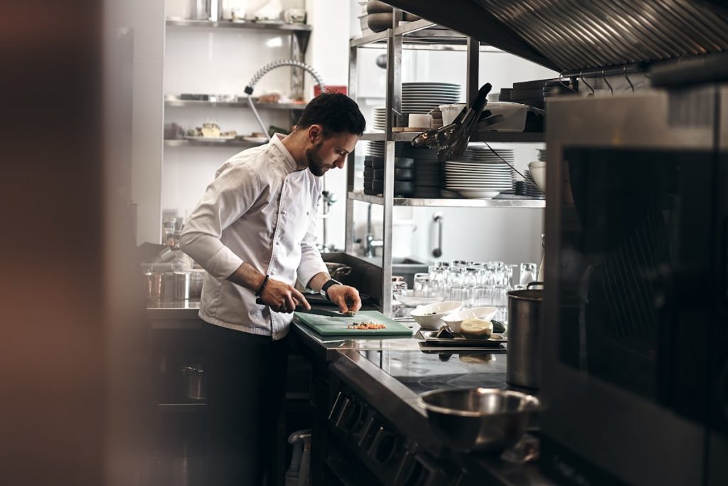 Cuisinier preparant des ingredients dans une cuisine professionnelle