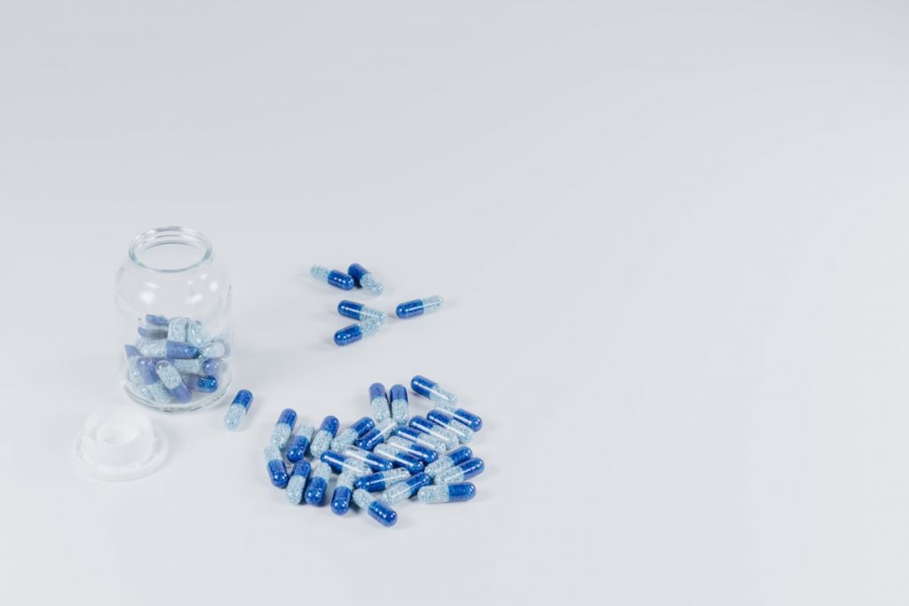 Gelules bleues et blanches sur un fond clair neutre