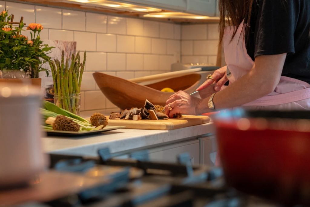 Personne coupant des legumes dans une cuisine lumineuse