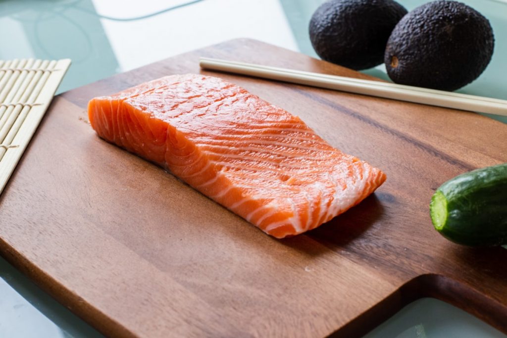 Pave de saumon frais et avocat sur une planche en bois
