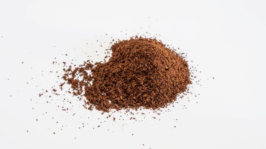Poudre de cacao non sucrée dans un bocal, cuillère et étiquette posées sur un plan de travail