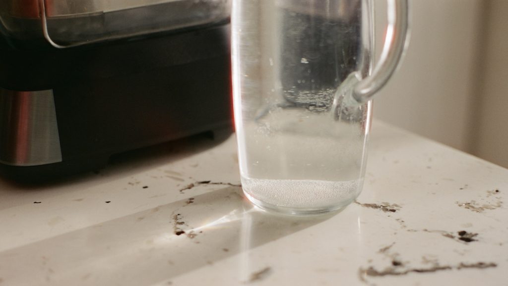 Verre d'eau posé sur un plan de travail clair dans la lumière du matin