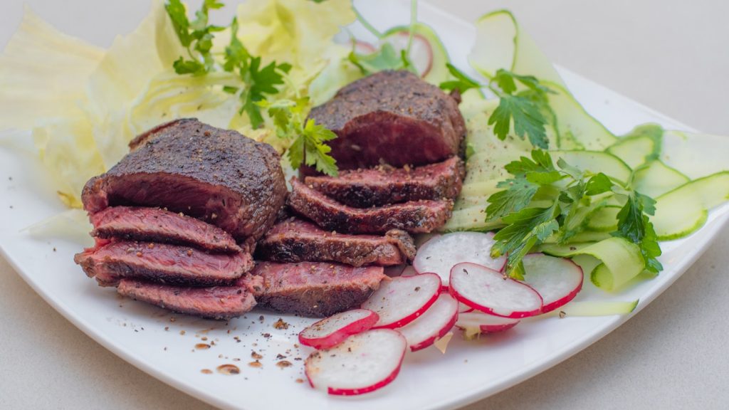 Tranches de foie de veau cru posées sur du papier de boucher, lumière naturelle